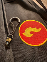 Close-up of the Skwok Bag zipper detail featuring a colorful logo on durable fabric.