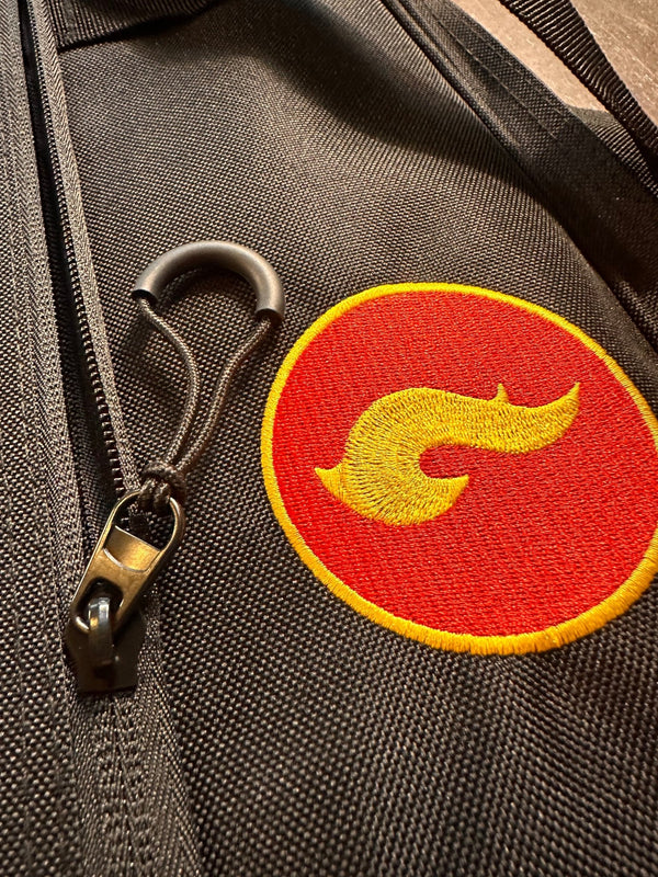 Close-up of the Skwok Bag zipper detail featuring a colorful logo on durable fabric.